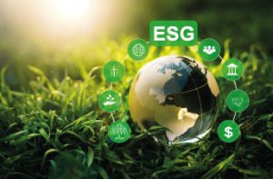 Eine Glasweltkugel liegt auf Rasen und drüber steht "ESG"