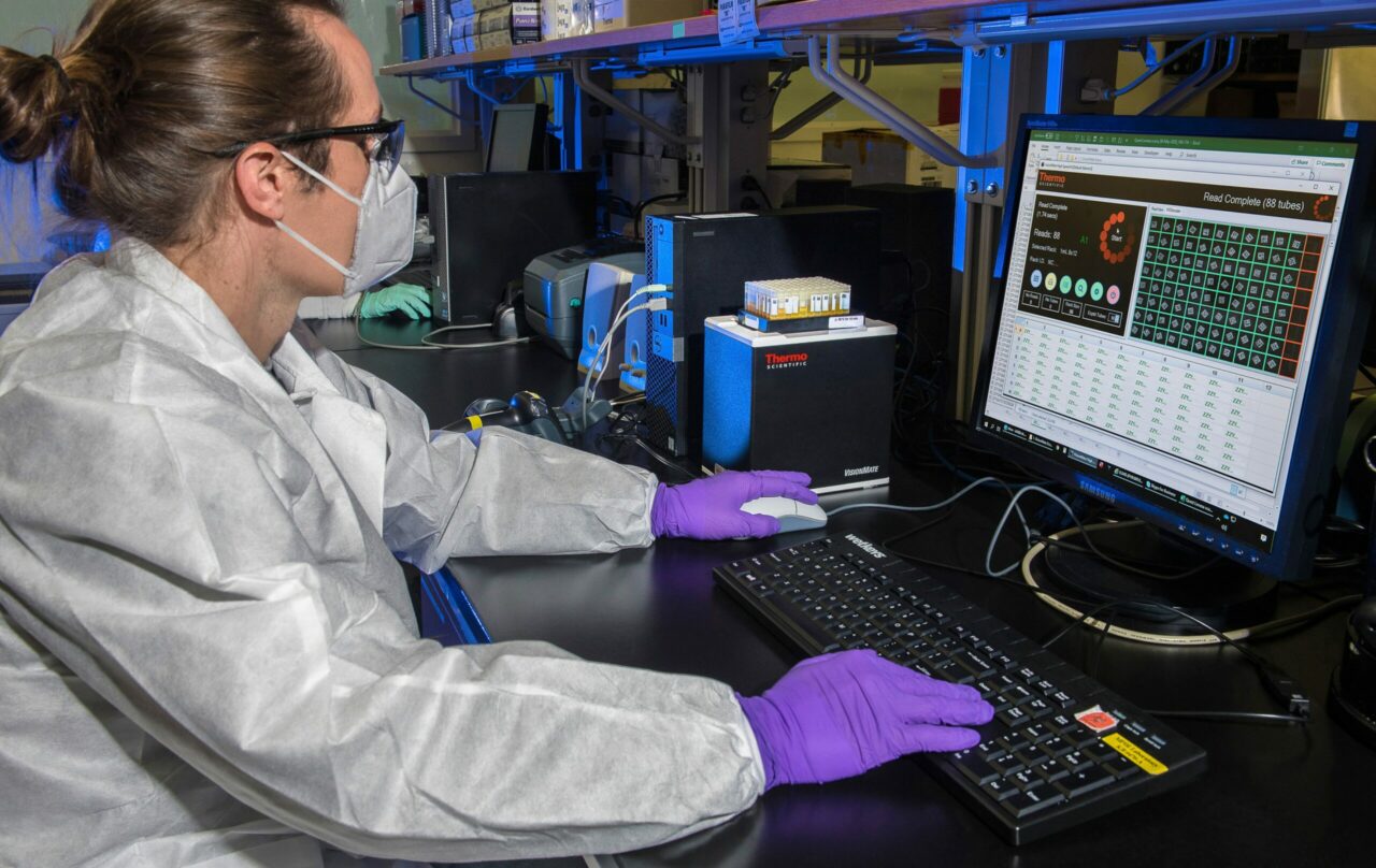 man is sitting in a lab and work on a computer