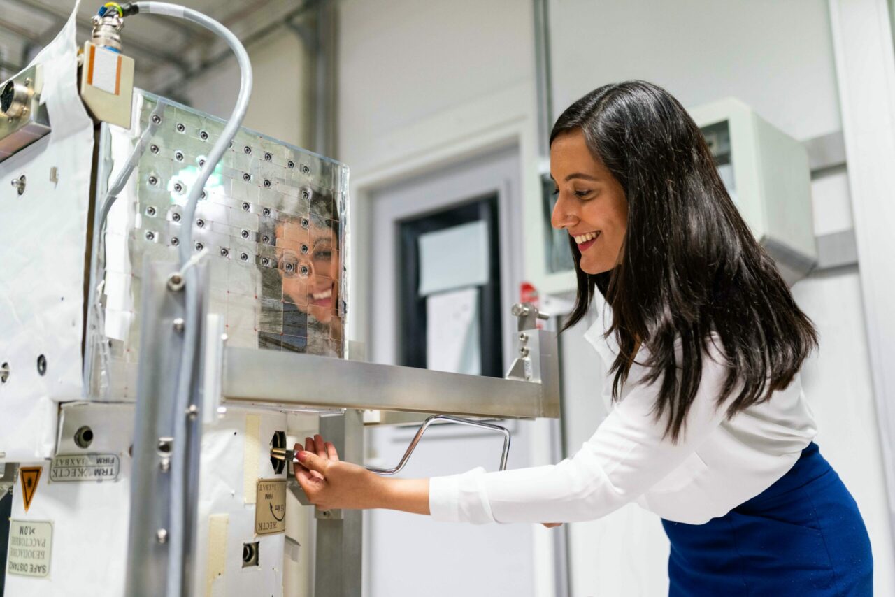 Female space operations engineer maintains equipment