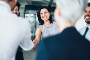 A businesswoman shaking hands with a businessman