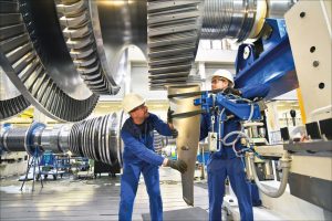 Workers working on a large gearbox